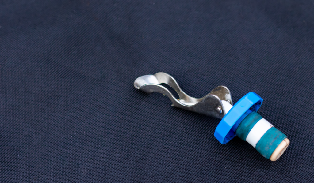 Reusable wine stopper with lever on dark fabric background