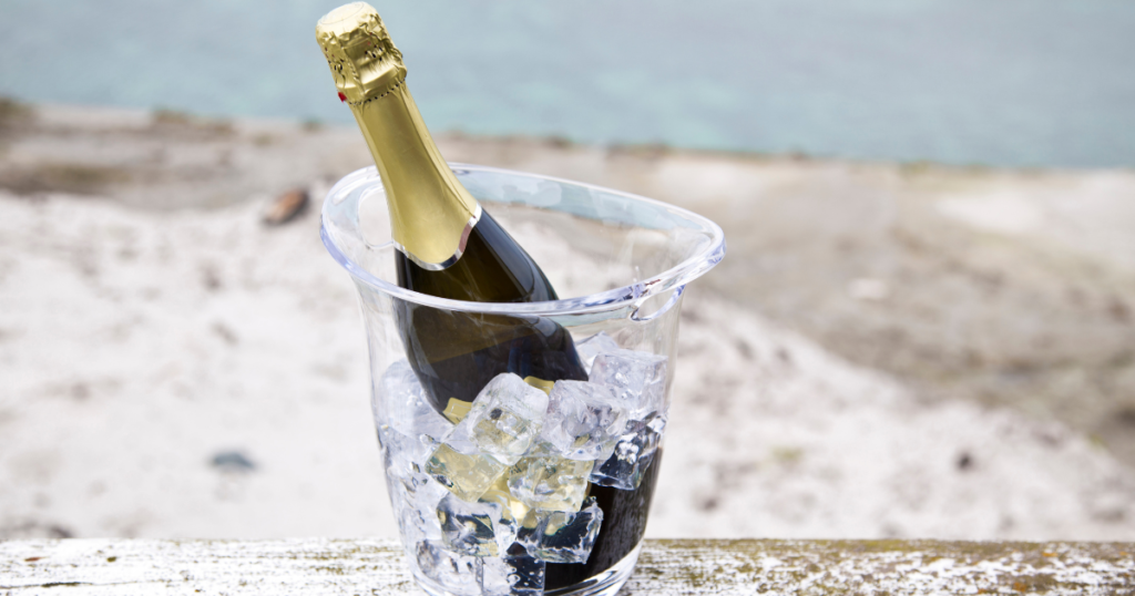 Champagne bottle chilling in ice bucket by the beach