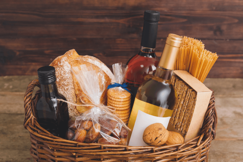 Wine gift basket with pasta, bread, olive oil, cookies, and bottles.
